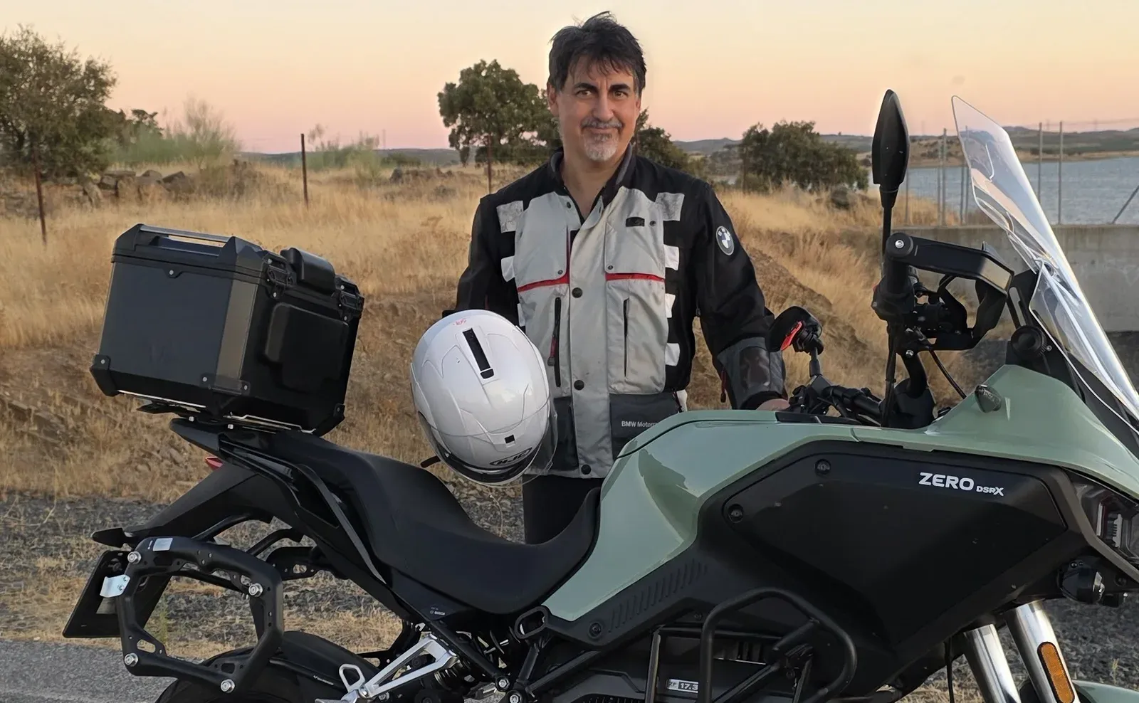 Tomás de la Hera junto a una moto eléctrica al atardecer